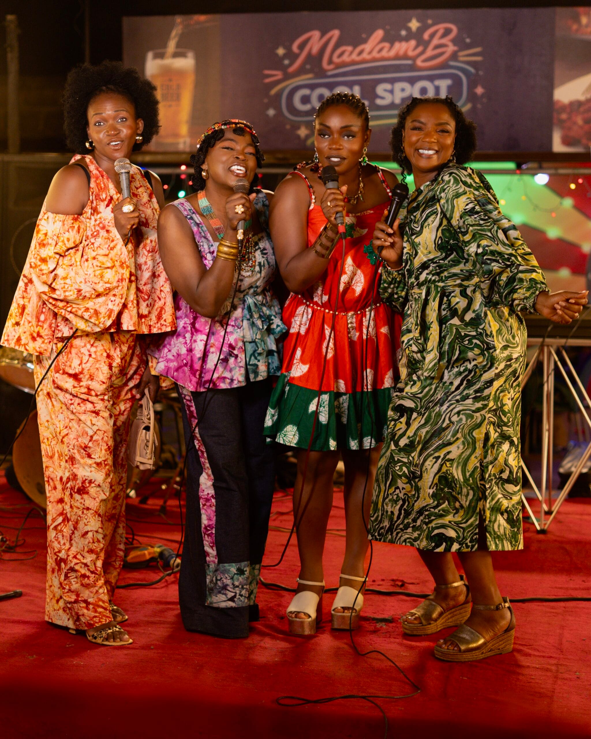 Four women singing together on stage