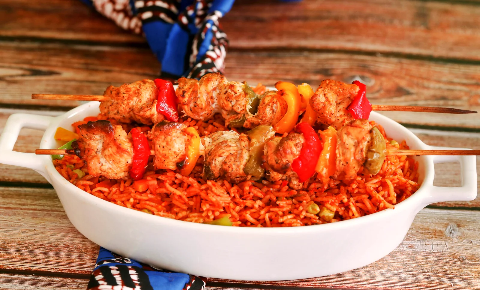 Jollof rice and grilled chicken combo on a dark plate